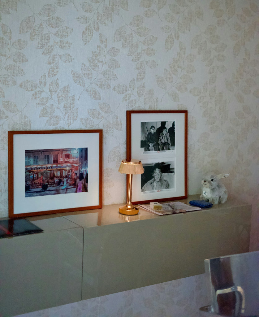 Two framed pictures, a small lamp, and a plush rabbit on a shelf